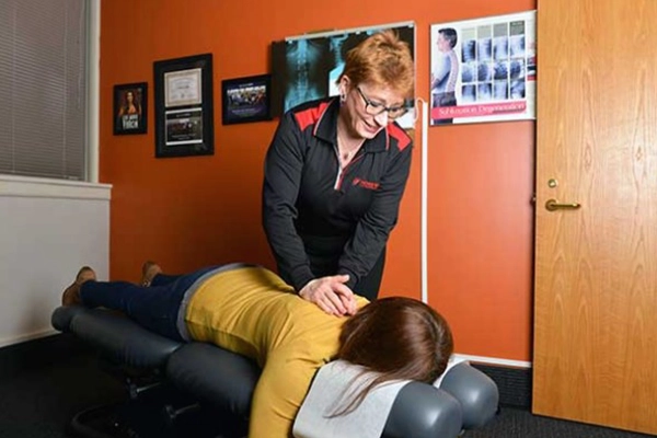 Chiropractor Roseville MN Patricia Wolff Adjusting Patients Neck In Orange Room