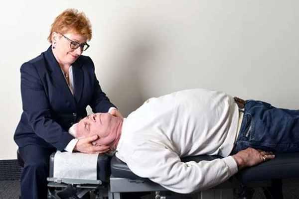 Chiropractor Roseville MN Patricia Wolff Examining Patients Neck