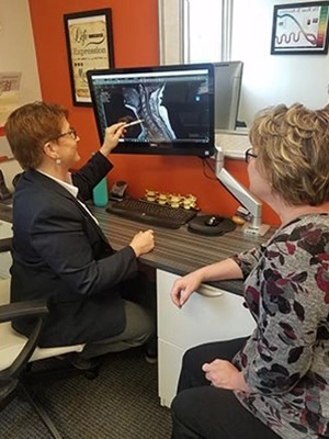 Chiropractor Roseville MN Patricia Wolff Pointing To XRay