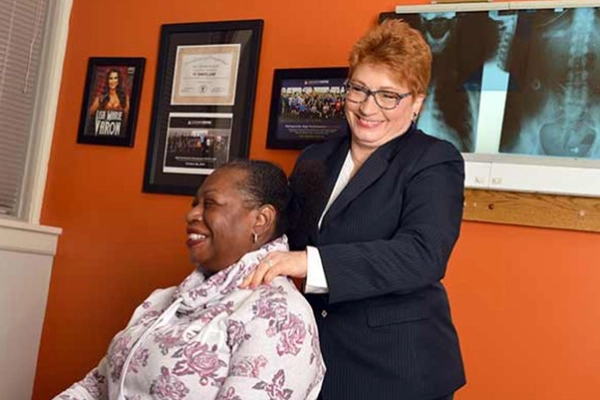 Chiropractor St Paul MN Trish Wolff Adjusting Patient In Orange Room